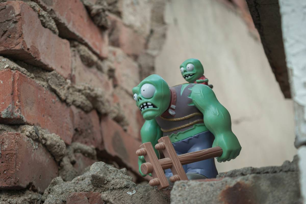 gaming strategy zombie survival ten way: player scavenging in ruined urban environment with zombies nearby